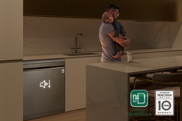 رجل يحمل طفلاً نائمًا في مطبخ خافت الإضاءة، وغسالة أطباق تعمل بهدوء في الخلفية.	