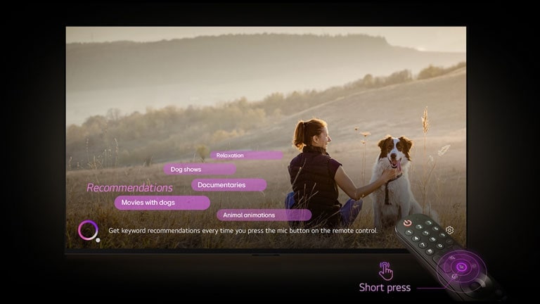 يعرض تلفزيون LG AI TV صورة لامرأة وكلب في حقل شاسع. في أسفل الشاشة، يظهر النص "احصل على توصيات الكلمات الرئيسية في كل مرة تضغط فيها على زر الميكروفون في جهاز التحكم عن بُعد." بجوار رسم دائرة وردية أرجوانية. تُظهر الأشرطة الوردية الكلمات الرئيسية التالية كتوصيات: عروض الكلاب، رسوم متحركة للحيوانات، أفلام وثائقية، أفلام بها كلاب، استرخاء. أمام تلفزيون LG AI TV، يتم توجيه جهاز التحكم عن بُعد LG Magic Remote نحو التلفزيون مع وجود دوائر أرجوانية متحدة المركز بلون النيون حول زر الميكروفون. وبجانب جهاز التحكم عن بُعد، ويظهر رسم لإصبع يضغط على زر ونص "ضغطة قصيرة".