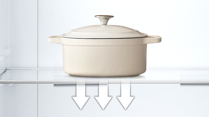 رف زجاجي مقوى يمسك بوعاء ثقيل داخل الثلاجة، مما يظهر قوته وسطحه سهل التنظيف	