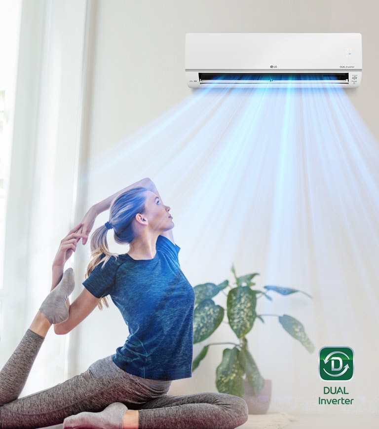 Woman doing yoga pose in front of a window under a cooling LG dual inverter air conditioner with blue air streams.