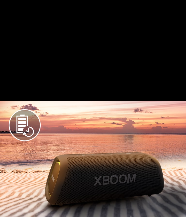 The speaker is placed on a beach towel. In front of the speaker, it shows sunset beach to illustrate that this speaker can be played up to 18 hours.