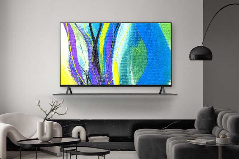 A TV is framed on a hotel wall’s shelf, and the TV screen shows works of art.