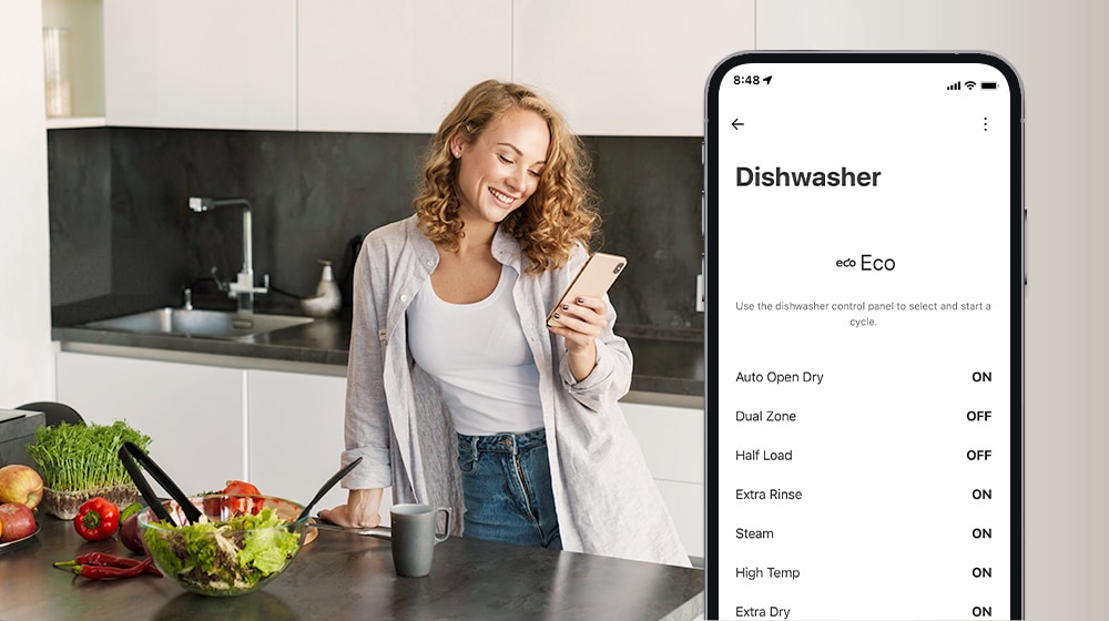 A woman is looking at her cell phone in the kitchen and a smartphone shows personalisation settings in the ThinQ™ app.