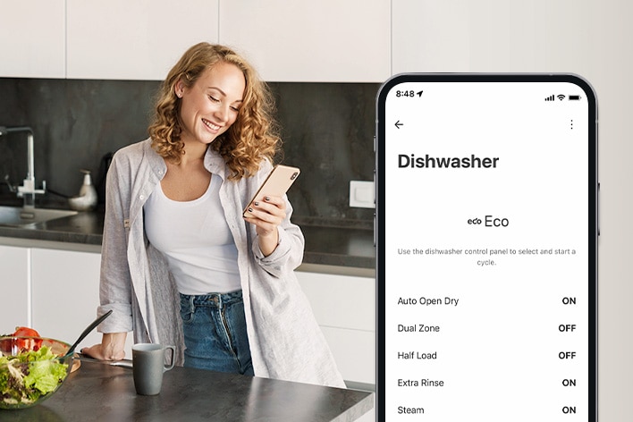 A woman is looking at her cell phone in the kitchen and a smartphone shows personalization settings in the ThinQ™ app. 