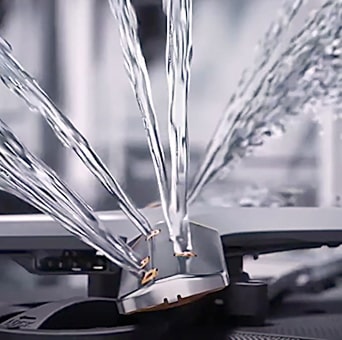 Close-up of powerful water jets inside an LG dishwasher, showcasing cleaning technology for thorough dishwashing results.