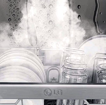 Close-up of dishes and glasses being steam-washed inside dishwasher.	