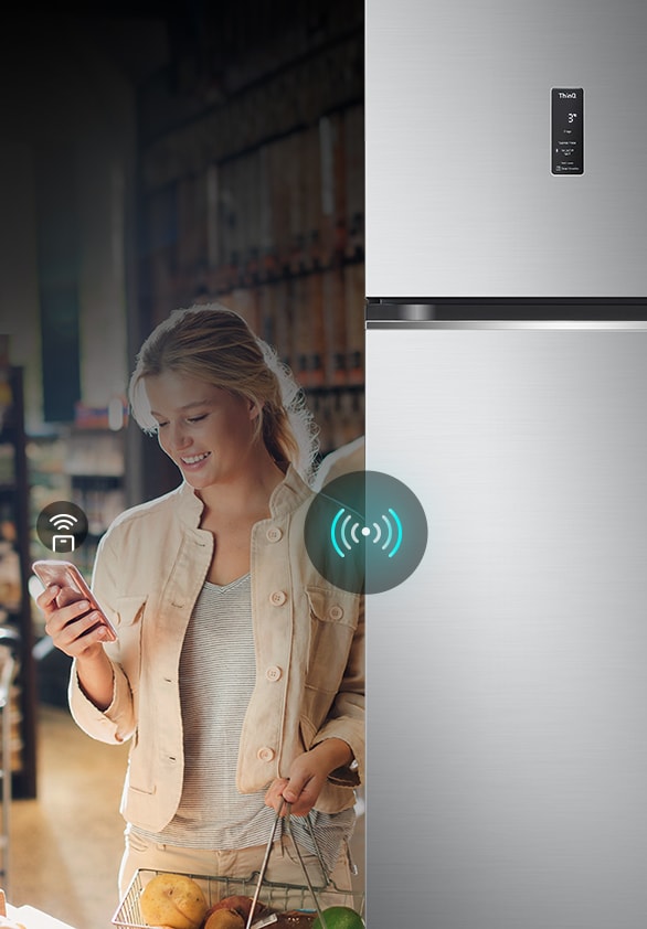 A woman controlling an lg refrigerator remotely using her smartphone. The image highlights the refrigerator's smart connectivity, allowing users to manage and adjust settings from their mobile device.	