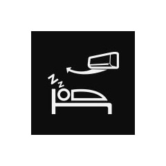  Person sleeping in bed with air conditioner above, blowing cool air downwards, ensuring a comfortable sleep.