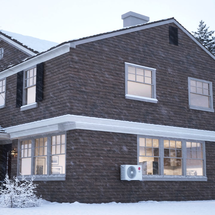 LG air conditioner for extreme cold climates, with an outdoor unit in snow and warm airflow filling a cozy living room.
