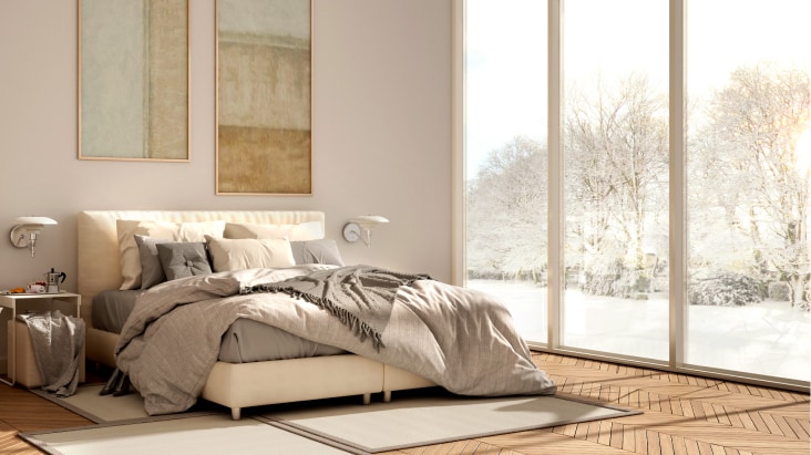 Bedroom with snowy view, showcasing LG air conditioner's low heating technology for efficient winter warmth.