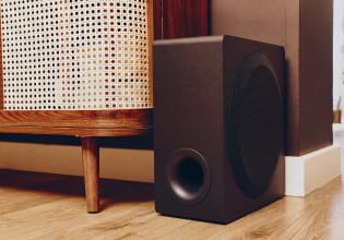 Subwoofer inalámbrico junto a un mueble de madera en el salón