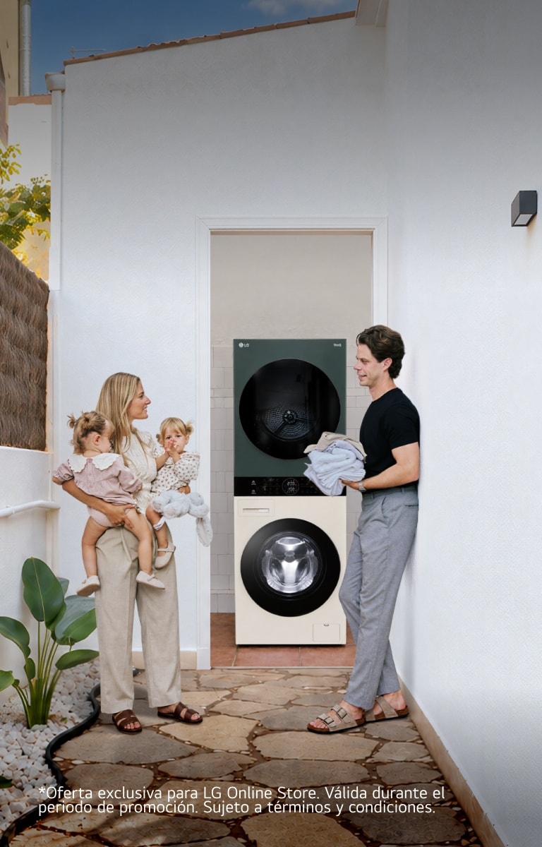 Una familia con gemelos pequeños de pie en un pasillo exterior de paredes blancas, junto a una lavadora y una secadora LG apiladas.