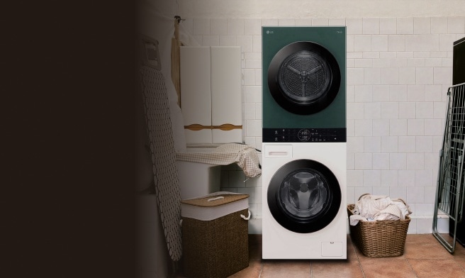 Torre de lavado LG WashTower con la secadora en verde arriba y la lavadora en beige abajo, instalada en un cuarto de lavado de azulejos blancos, junto a cestos de mimbre con ropa.