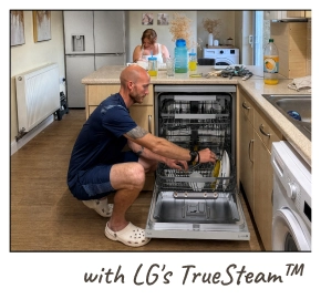 Un hombre se arrodilla en el suelo, cargando platos en un lavavajillas LG abierto. [con LG TrueSteam™]