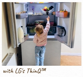 Un niño alcanza el interior de un refrigerador abierto e iluminado. [con LG ThinQ™]
