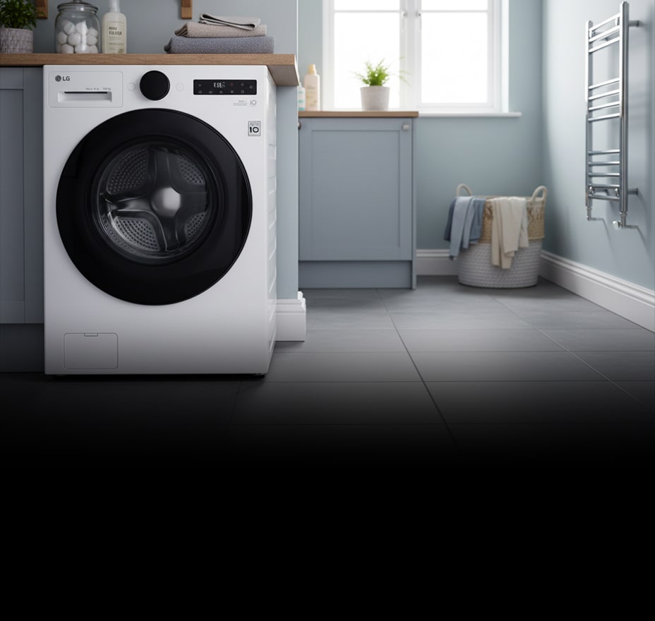 A white front-loading washing machine is installed in a bright laundry room with pastel cabinetry and a window.
