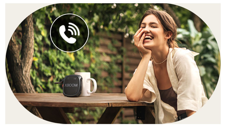 Una mujer está hablando por teléfono a través del modo de teléfono con altavoz LG XBOOM XG2.