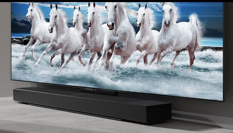 La barra de sonido y el televisor se colocan sobre la mesa blanca y se muestran 7 caballos blancos en el televisor.