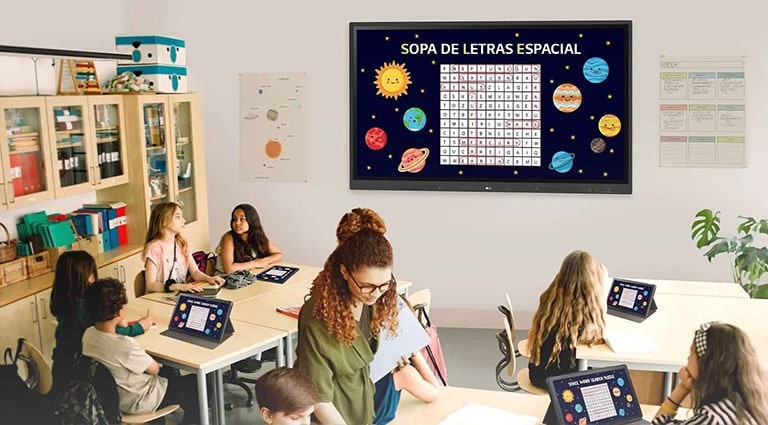 Class is being conducted in the classroom, and the class material screen which is displayed on the classroom wall's LG CreateBoard is being shared on the students' tablets.