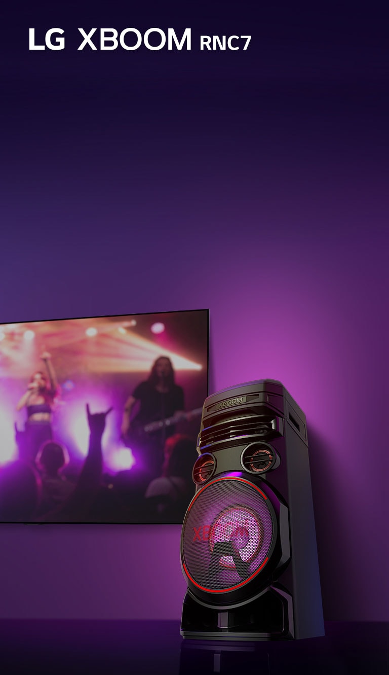 Una vista de ángulo del lado derecho de LG XBOOM RNC7 sobre un fondo púrpura. La luz de XBOOM también es morada. Y una pantalla de un TV muestra una escena de concierto.