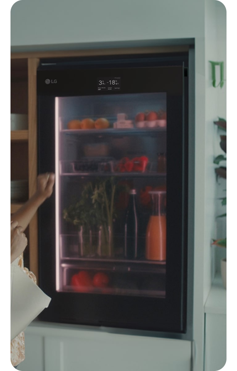 Image of a woman knocking on the top of a refrigerator.