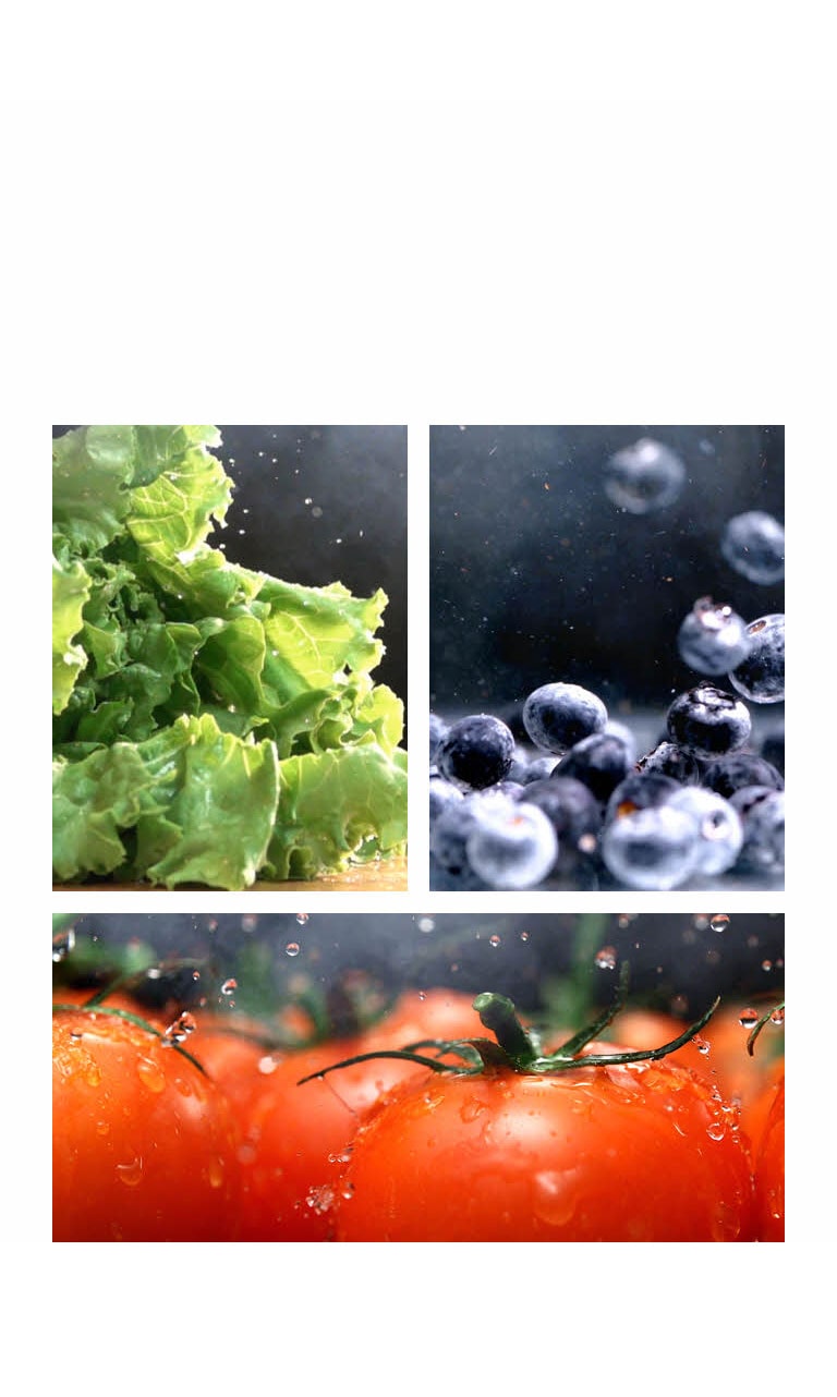 Hojas de lechuga a la izquierda, tomate rojo al centro y arándanos a la derecha bajo gotas de agua fresca.