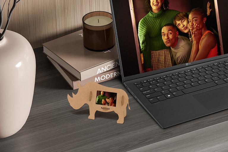 Muestra el marco de fotos con forma de rinoceronte encima de la mesa.