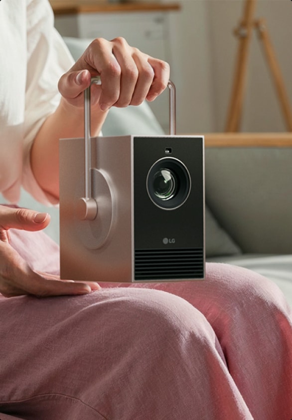 Imagen de una persona sosteniendo el asa giratoria de 360 grados del LG CineBeam Q.