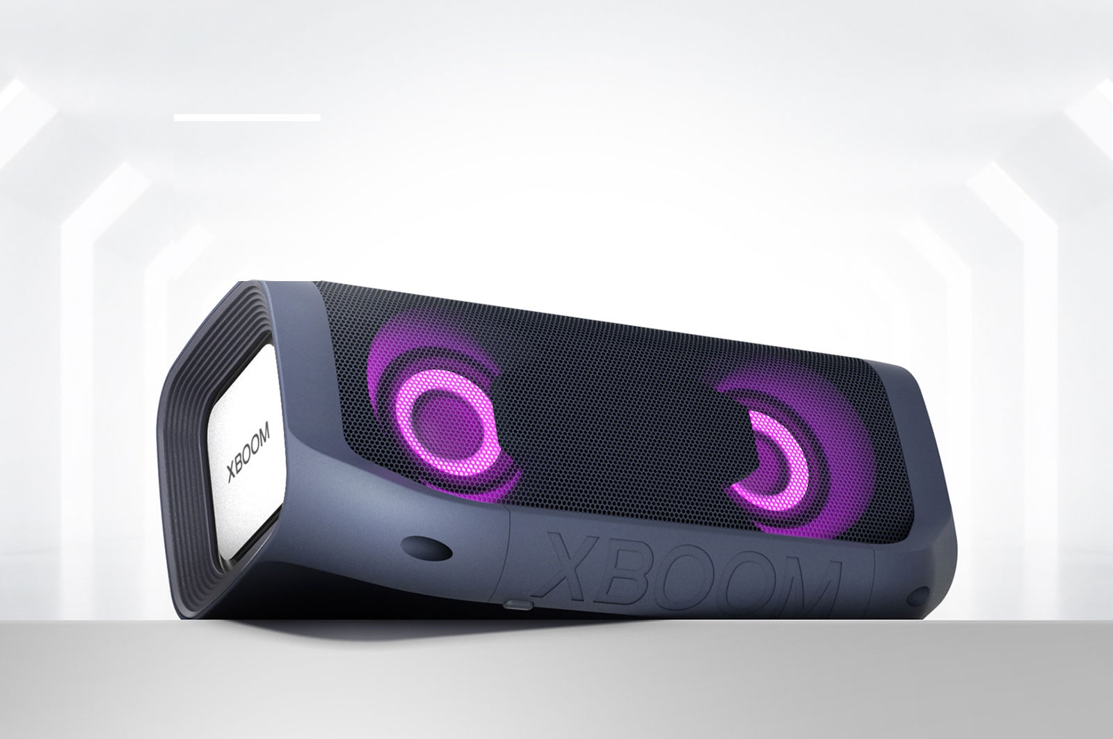 Un LG XBOOM Go con iluminación magenta está colocado de forma angular en un estante gris.