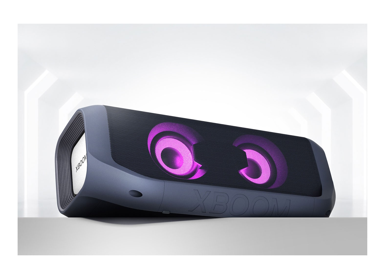 Un LG XBOOM Go con iluminación magenta está colocado de forma angular en un estante gris.