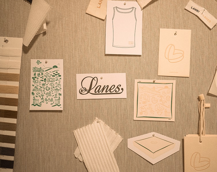 Tablero de inspiración con bocetos de prendas, el logotipo de Lanes y muestras de tela.