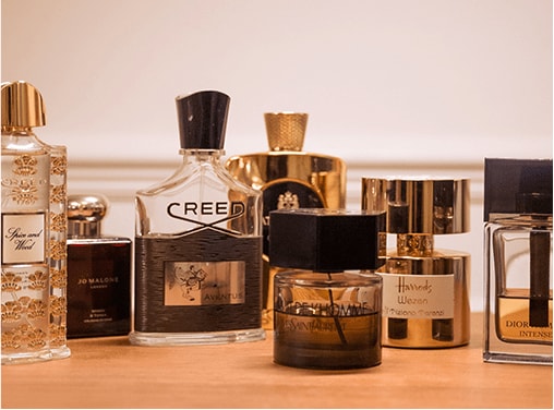 Una colección de perfumes expuestos sobre una superficie de madera.