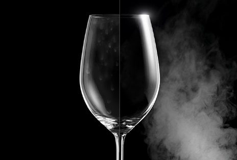 Una copa de vino con manchas de agua por un lado, y clara e impoluta por el otro después de lavarla con vapor.
