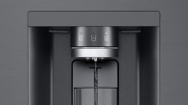 *Comienza un vídeo ampliado sobre el dispensador de agua. El exterior del frigorífico se aclara y ahora se puede ver el interior de la puerta y las partes mecánicas de la boquilla dispensadora. El vídeo se amplía para mostrar las gotas de agua cayendo a través de la parte UVnano de la boquilla que reduce las bacterias. La imagen se aleja para volver a ver el exterior del frigorífico mientras se dispensa agua en un vaso.