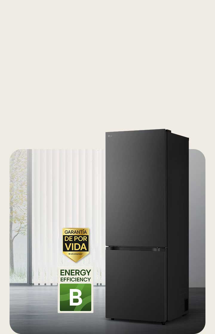 Vista frontal de un congelador inferior LG negro mate, colocado en una habitación luminosa con persianas verticales. A continuación se muestran la garantía de 10 años del compresor y los iconos de eficiencia energética A.