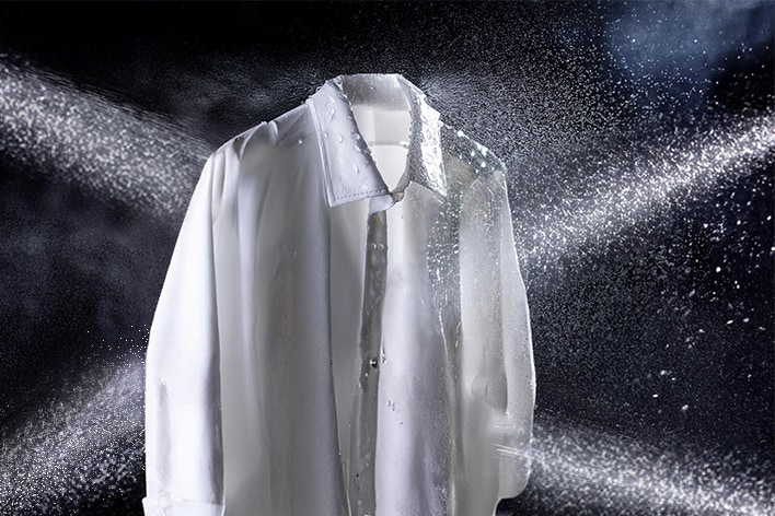 Imagen de agua pulverizada sobre camisetas con cuatro chorros pulverizadores. 