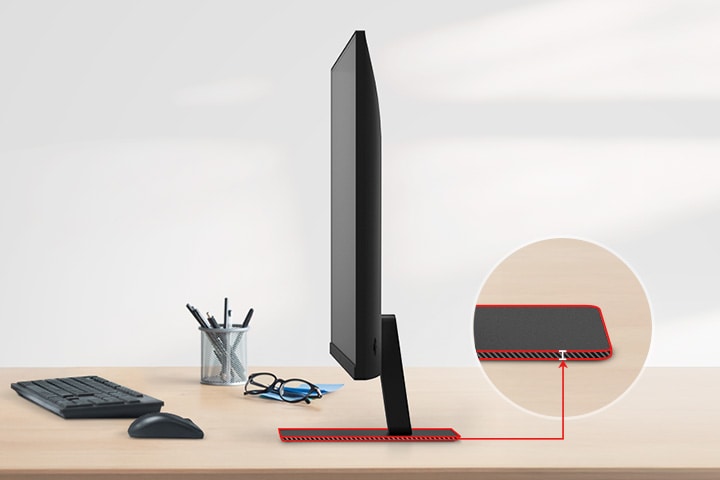 Un monitor QHD con un soporte ultradelgado está sobre el escritorio, con un portalápices, gafas, un teclado y un mouse junto a él.