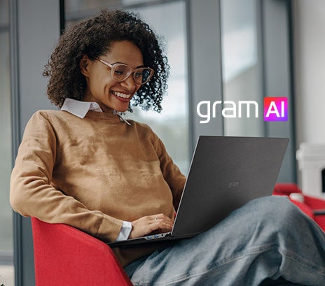 La imagen muestra a una mujer sonriente que utiliza un ordenador portátil sentada en un entorno moderno y acogedor. El texto dice: «Tu propio asistente con inteligencia artificial» junto al logotipo “gram AI”, que destaca las funciones de asistencia con inteligencia artificial del dispositivo