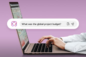 Esta imagen muestra unas manos escribiendo en un portátil, con una barra de búsqueda que muestra la pregunta: «¿Cuál fue el presupuesto global del proyecto?