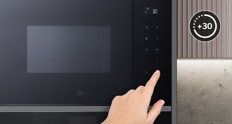 Doigt touchant le panneau tactile du micro-ondes.