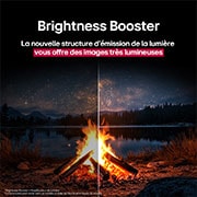 Feu de camp la nuit en plein milieu de la nature. Au loin se trouve une forêt et un lac. Le ciel nocturne est rempli d’étoiles. Toute la scène est divisée en deux. Un côté est plus sombre et plus terne. L’autre moitié est remarquablement plus lumineuse, mettant en valeur l’éclat impressionnant de l’amplificateur de luminosité. 