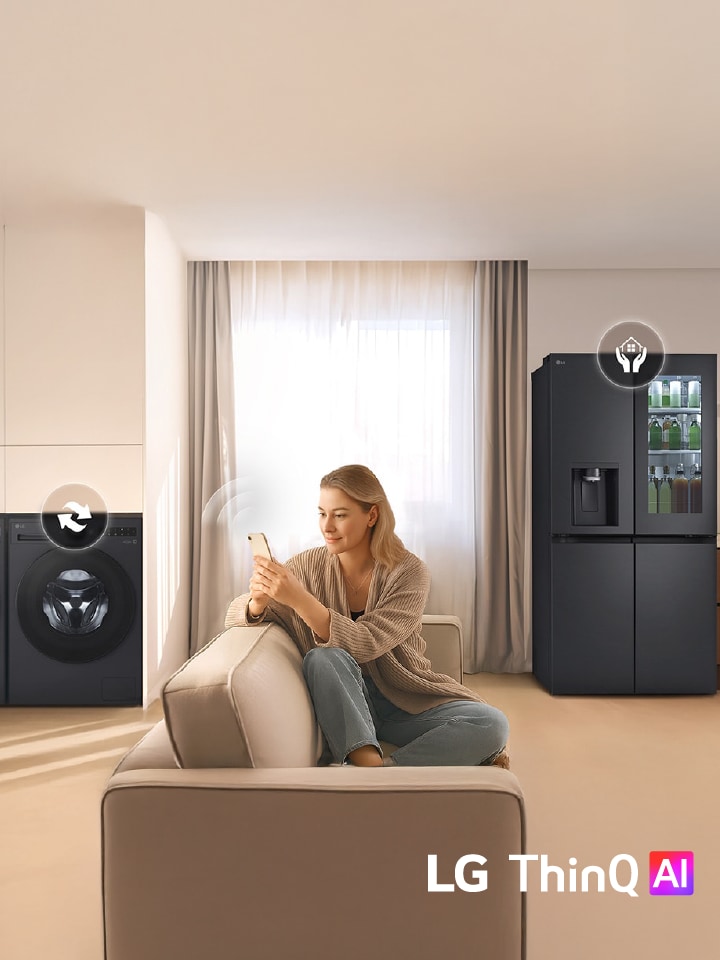 Woman on sofa using phone to control LG washer and fridge in bright living room
