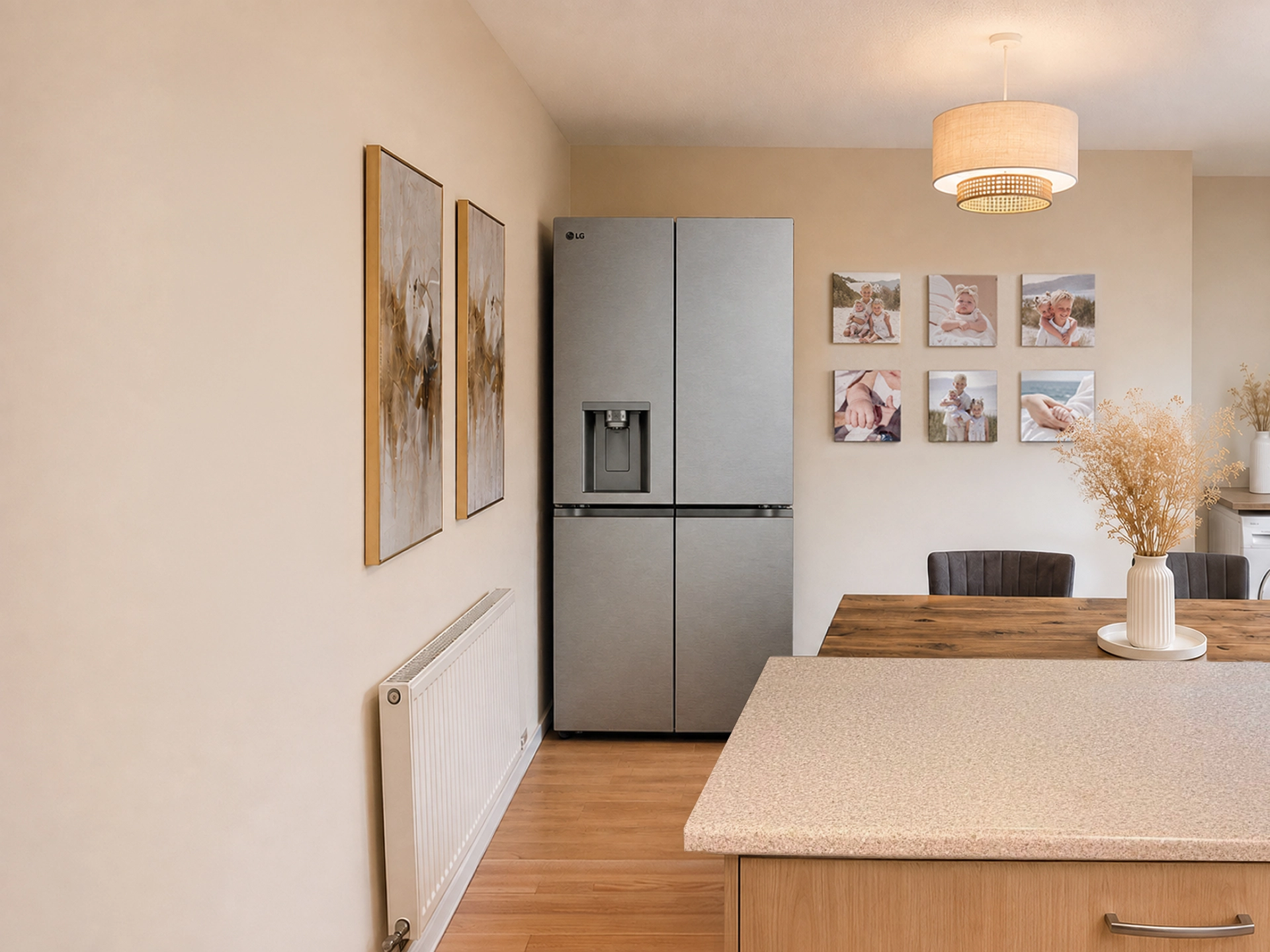 Un réfrigérateur-congélateur LG multi-portes en acier inoxydable se trouve dans une salle à manger chaleureuse et moderne, à côté d’une table en bois et d’une décoration murale.