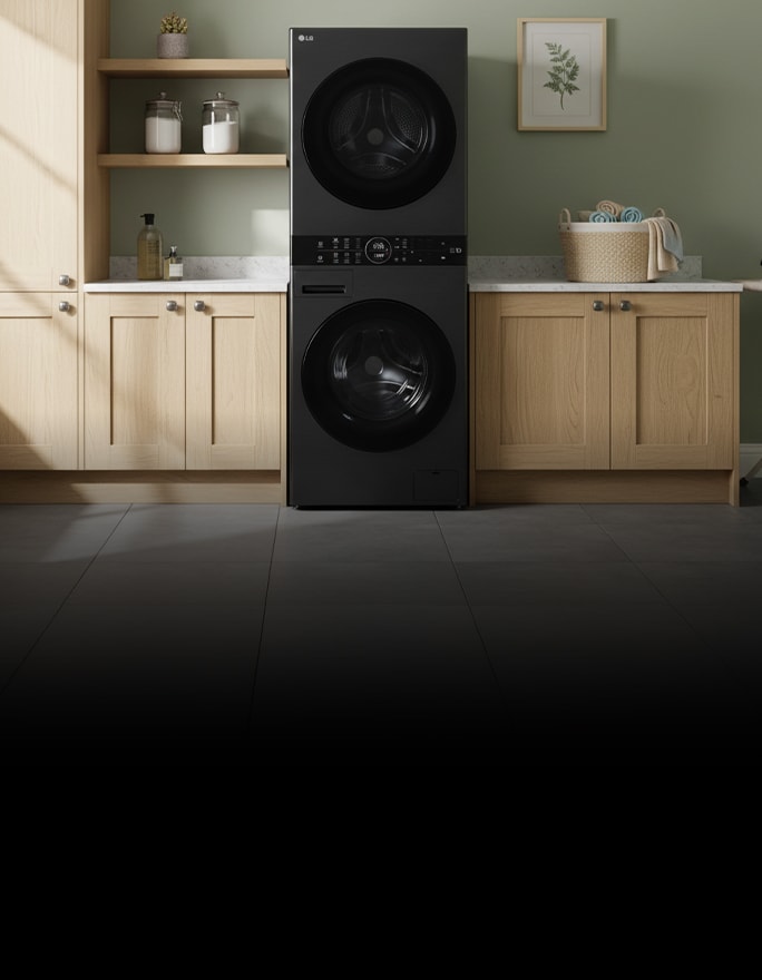 A black WashTower is installed within a closet unit, surrounded by shelves holding folded towels, clothing, and storage boxes.