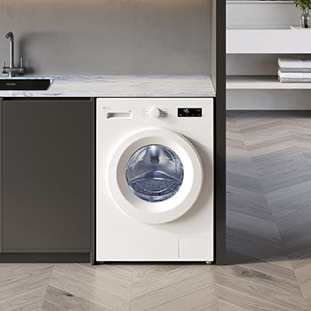 Lave-linge LG F854B13WHS blanc installé sous un plan de travail en marbre dans une buanderie moderne avec un sol en chevrons.