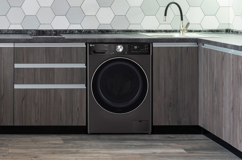 Le lave-linge LG F34R92BSTA de 13 kg en Platinum Black, soigneusement installé sous un comptoir dans une cuisine moderne.