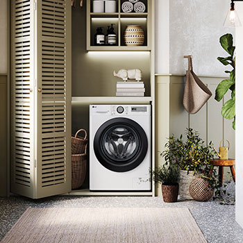 Lave-linge LG F14R15WHS blanc installé dans une buanderie confortable avec des placards à persiennes et des plantes vertes.