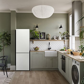 Réfrigérateur-congélateur LG GBB61SWJEC blanc, intégré dans une cuisine moderne aux tons verts, mettant en valeur son design élégant à porte plate.