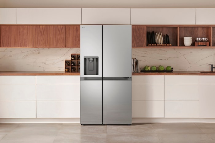 Réfrigérateur Américain LG GSJC40PYPE Argent Premium avec distributeur d'eau et de glace, intégré élégamment dans une cuisine moderne aux armoires blanches et en bois.