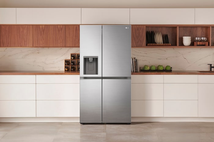 Réfrigérateur Américain LG GSLV81PZLE Argent Premium avec distributeur d'eau et de glace, intégré élégamment dans une cuisine moderne aux armoires blanches et en bois.